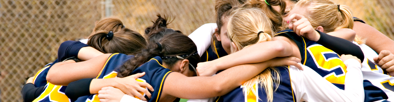 Young athlete - softball team in huddle - diverse - for web